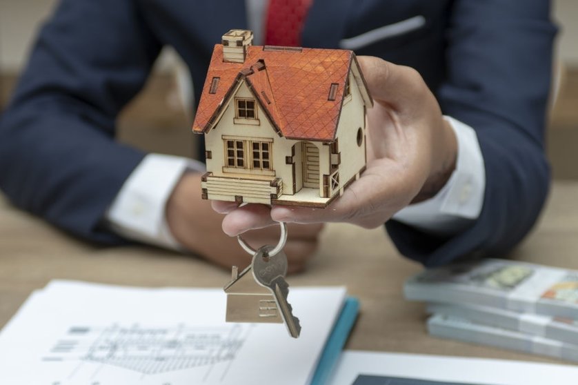 business man hand key and house model